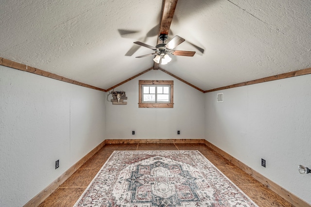 additional living space with ceiling fan, vaulted ceiling, and a textured ceiling