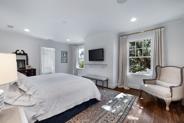 bedroom with crown molding, ensuite bath, and dark hardwood / wood-style flooring