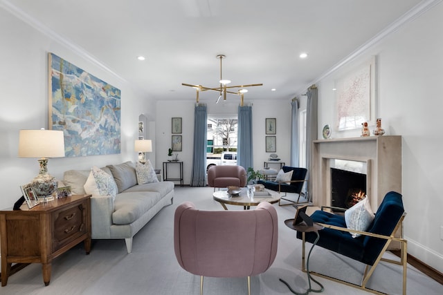 living room featuring crown molding, a fireplace, and a chandelier