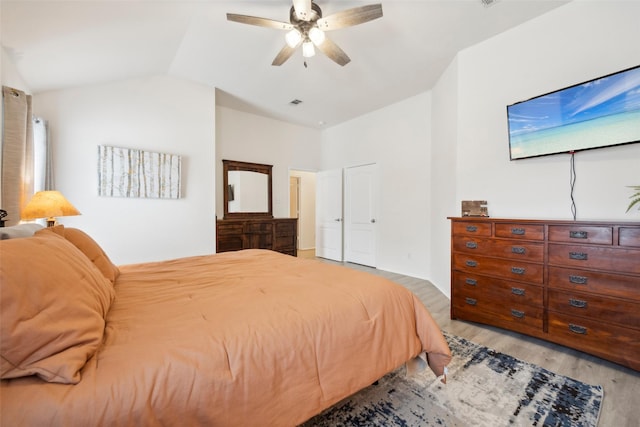 bedroom with lofted ceiling, light hardwood / wood-style flooring, and ceiling fan