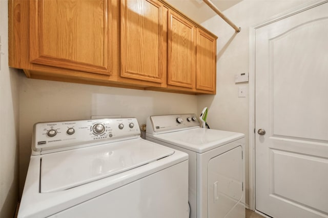 laundry room featuring washer and dryer and cabinets