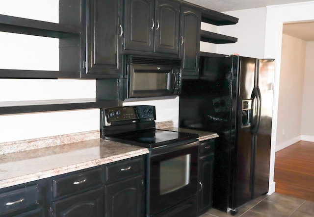 kitchen with dark tile patterned floors and black appliances