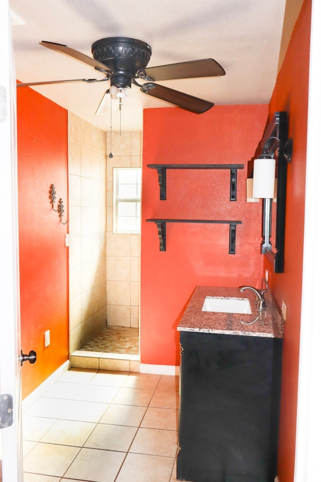 bathroom with vanity, tile patterned flooring, ceiling fan, and a tile shower