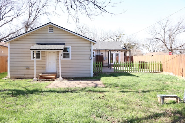 rear view of property with a yard and a patio