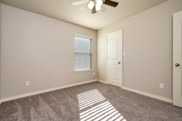 spare room with ceiling fan and dark carpet