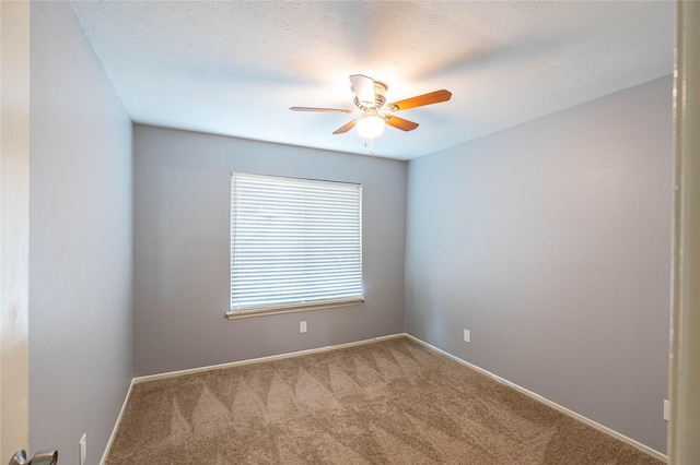 carpeted empty room featuring ceiling fan and a textured ceiling