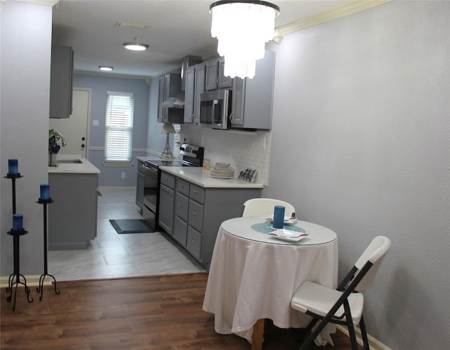 kitchen with sink, gray cabinetry, dark hardwood / wood-style flooring, decorative backsplash, and black / electric stove