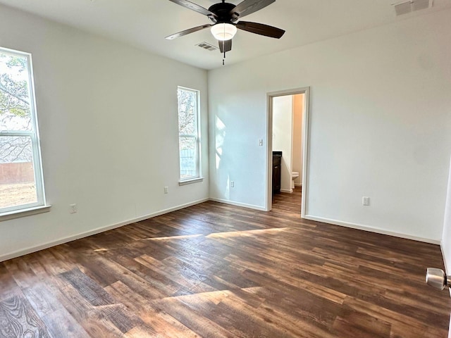 spare room with dark wood-type flooring and ceiling fan