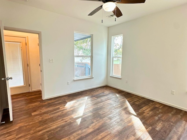 empty room with ceiling fan and dark hardwood / wood-style flooring