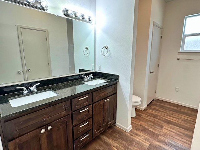 bathroom with vanity, wood-type flooring, and toilet