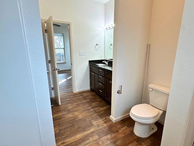 bathroom featuring wood-type flooring, toilet, and vanity