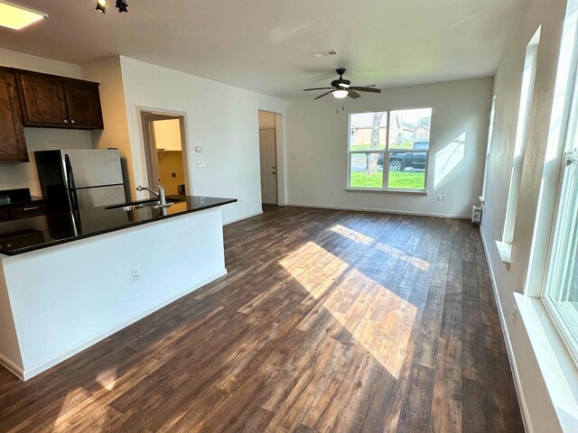 kitchen with sink, stainless steel refrigerator, ceiling fan, dark brown cabinets, and dark hardwood / wood-style flooring