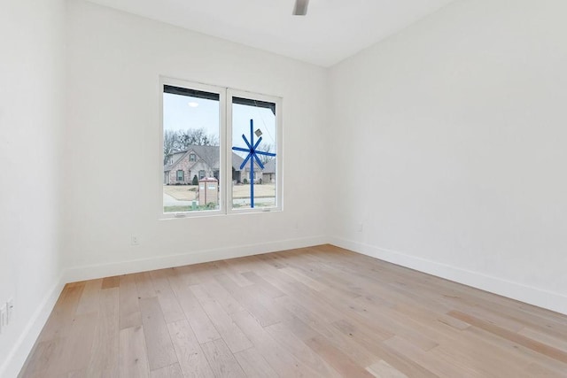 empty room with ceiling fan and light hardwood / wood-style floors