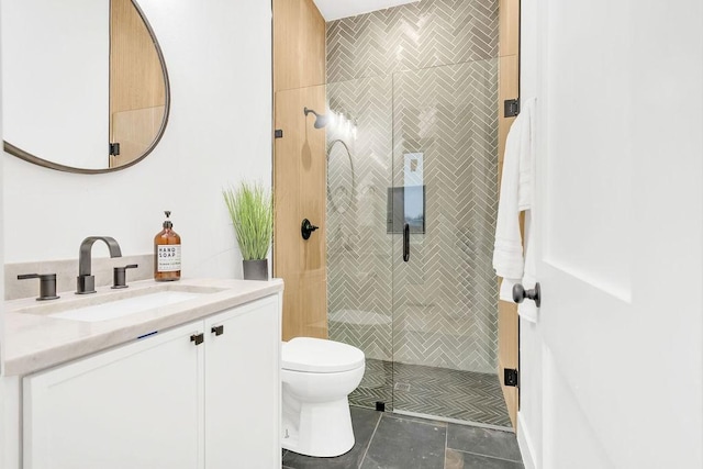 bathroom featuring vanity, a tile shower, and toilet