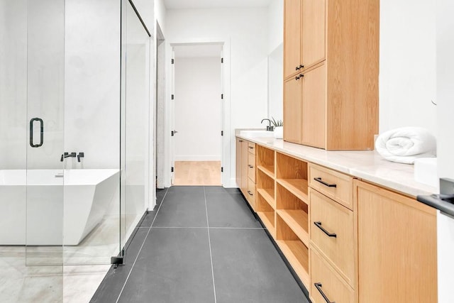 bathroom with tile patterned flooring, vanity, and a bathtub