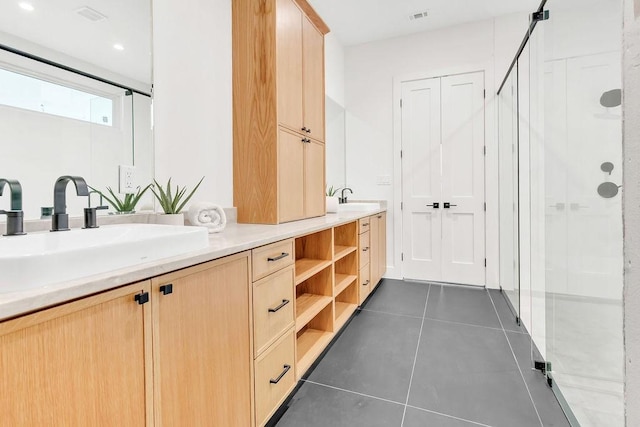 bathroom with tile patterned flooring, vanity, and walk in shower