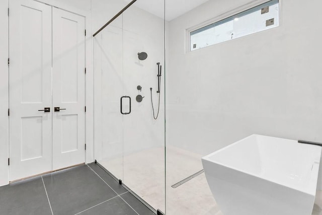 bathroom featuring shower with separate bathtub and tile patterned flooring