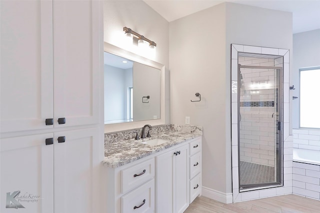 bathroom featuring vanity, plus walk in shower, and hardwood / wood-style floors