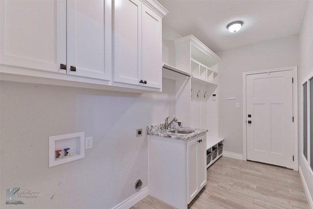 laundry area with sink, electric dryer hookup, hookup for a washing machine, cabinets, and light wood-type flooring