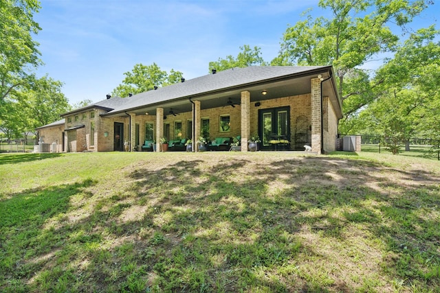 back of house with fence, brick siding, french doors, ceiling fan, and a lawn