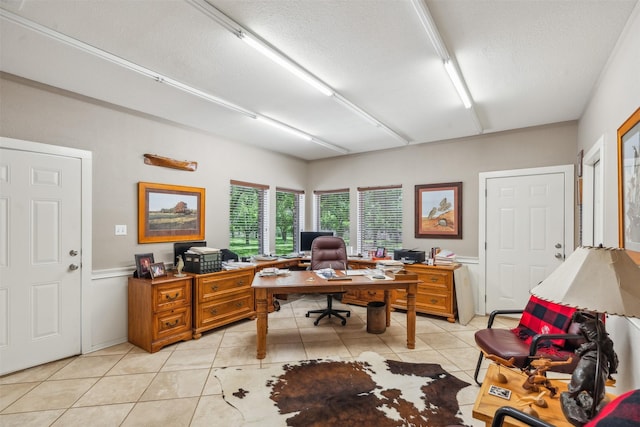 home office featuring light tile patterned floors and a textured ceiling