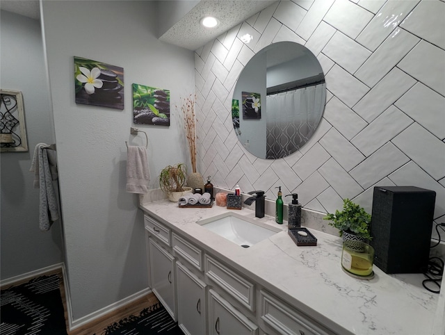 bathroom featuring vanity and backsplash