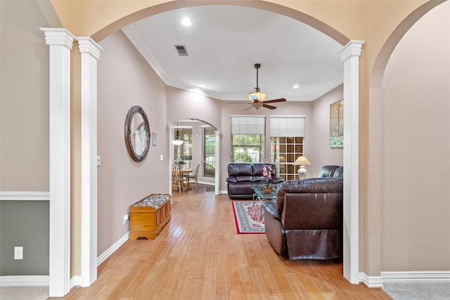 living room featuring ceiling fan, ornamental molding, light hardwood / wood-style flooring, and ornate columns