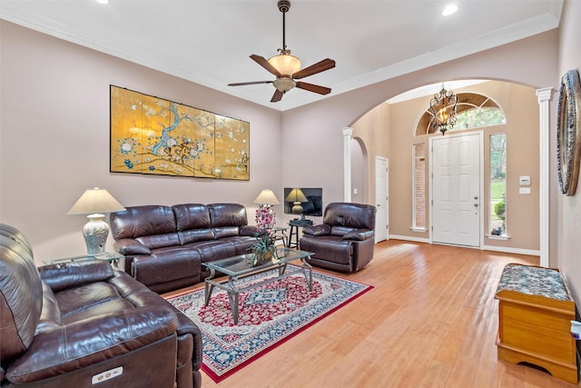 living room with decorative columns, crown molding, ceiling fan, and light hardwood / wood-style flooring