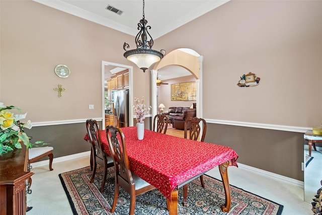 dining area featuring ornamental molding and light carpet