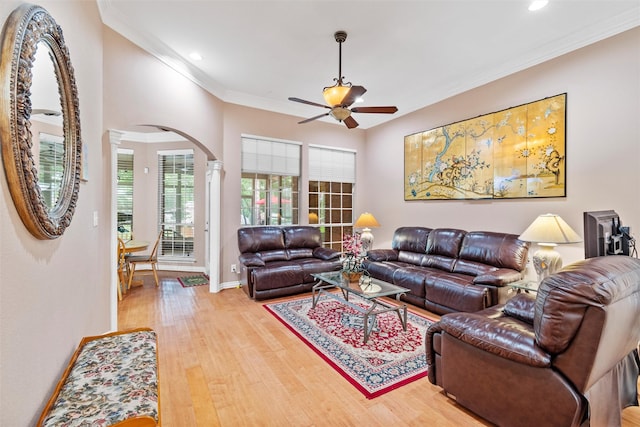 living room with light hardwood / wood-style flooring, ornamental molding, and ceiling fan