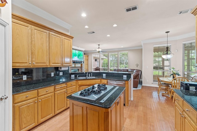 kitchen with crown molding, kitchen peninsula, sink, and a kitchen island