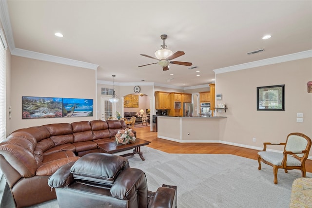 living room with crown molding, light hardwood / wood-style floors, and ceiling fan