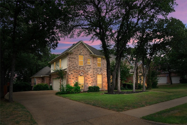 view of front of house with a garage and a yard