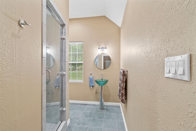 bathroom with an enclosed shower, vaulted ceiling, and tile patterned floors