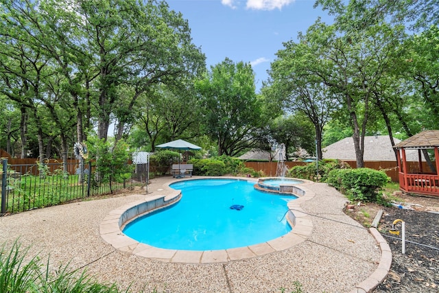 view of pool with a gazebo, a patio area, pool water feature, and an in ground hot tub