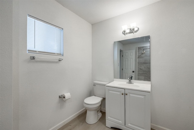 bathroom featuring vanity, a shower, hardwood / wood-style floors, and toilet