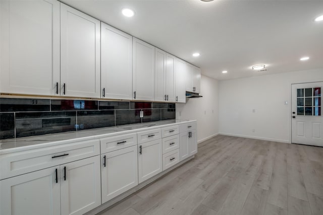 kitchen featuring tasteful backsplash, white cabinets, and light hardwood / wood-style flooring