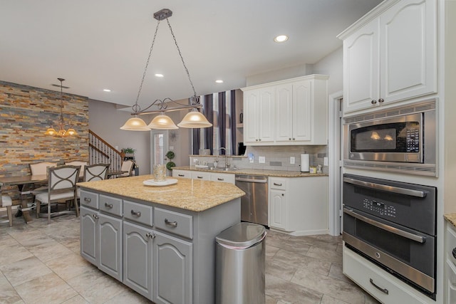 kitchen with pendant lighting, white cabinetry, and appliances with stainless steel finishes