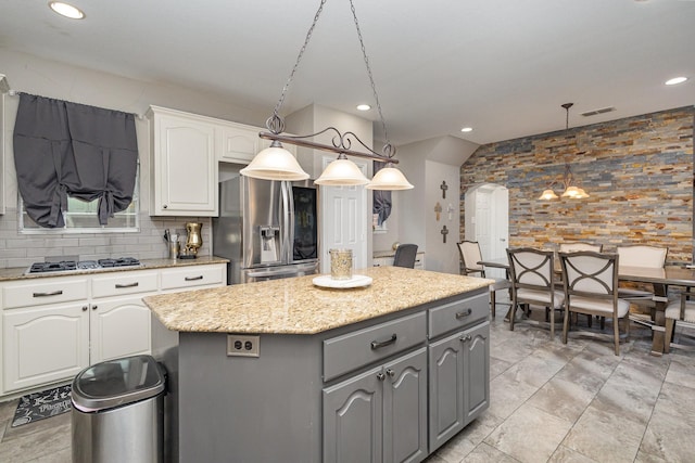 kitchen featuring gray cabinets, a kitchen island, pendant lighting, stainless steel appliances, and white cabinets