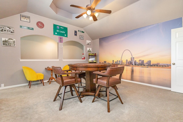 dining room with ceiling fan, bar, carpet flooring, and vaulted ceiling