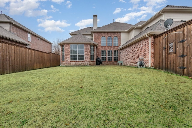 rear view of house featuring a lawn