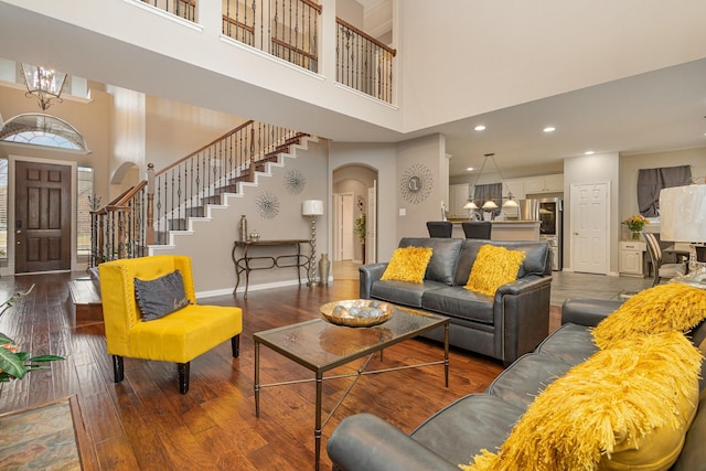 living room featuring an inviting chandelier, dark hardwood / wood-style floors, and a high ceiling