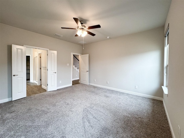 unfurnished bedroom with dark carpet and ceiling fan