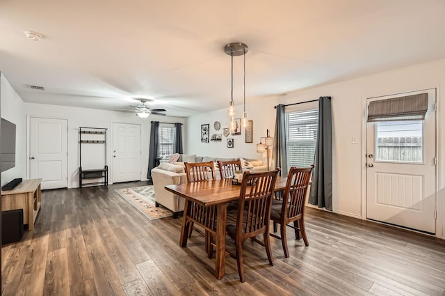 dining area with dark wood-type flooring and ceiling fan