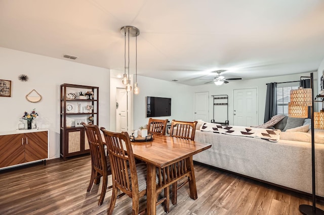 dining space with dark hardwood / wood-style floors and ceiling fan