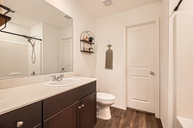 bathroom featuring vanity, hardwood / wood-style flooring, a shower, and toilet