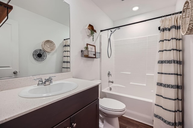 full bathroom featuring hardwood / wood-style flooring, shower / tub combo with curtain, vanity, and toilet