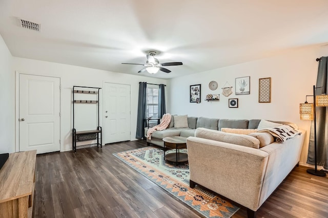 living room with dark wood-type flooring and ceiling fan