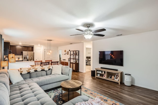 living room with ceiling fan and dark hardwood / wood-style flooring