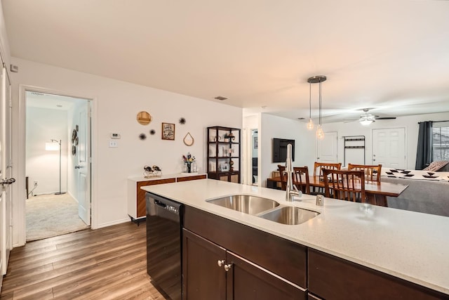 kitchen featuring sink, dishwasher, hanging light fixtures, dark brown cabinets, and wood-type flooring